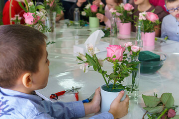 Children with Down syndrome at a master class on making bouquets. World Down Syndrome Day concept. ...