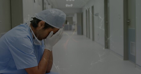 Image of moving spiral over sad biracial male nurse in hospital