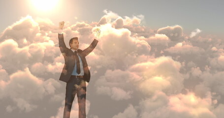 Image of biracial businessman with arms outstretched over sky with clouds