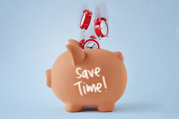 Piggy bank with falling alarm clocks - Concept of saving time - 767956288