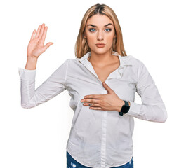 Young caucasian woman wearing casual clothes swearing with hand on chest and open palm, making a...