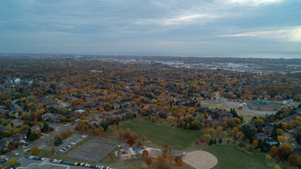 An aerial view of a Park with a Baseball Dimond and houses in the suburbs during Fall
