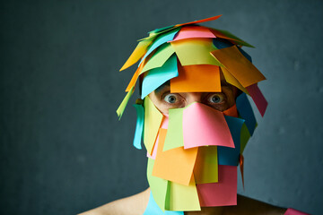Close up portrait of shocked man with colorful sticky notes all over his face over gray background - 767959845