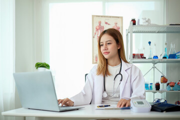 Female doctor working at office desk at in health clinic or hospital