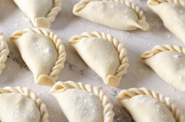 Uncooked Argentinian empanadas on a table. 