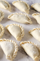 Uncooked Argentinian empanadas on a table.