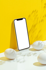 Eggs and smartphone mockup, template on yellow and white background