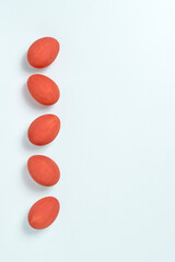 Red painted easter eggs aligned in a row on white background