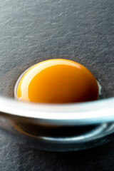 Close up shot of an egg yolk in glass bowl