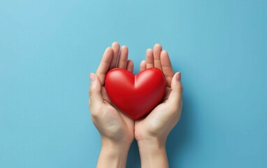 Fototapeta premium hands hold a red heart on a blue background