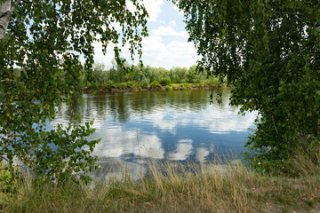 Landscape River with blue sky and clouds is reflected in the water on a summer day.