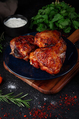 Grilled chicken meat in a dark plate on a stone table.