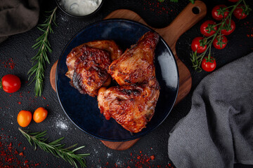 Grilled chicken meat in a dark plate on a stone table.