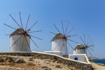 Fototapeta na wymiar Windmills with wooden blades against the blue sky in Mykonos, Greece
