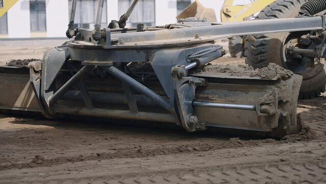 A motor vehicle equipped with automotive tires and wheels is moving dirt on a construction site, using its bumper and exterior to transport materials like wood and asphalt