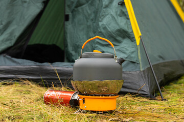 Tourist kettle on a gas burner. Cooking in field conditions. Using a tourist gas burner