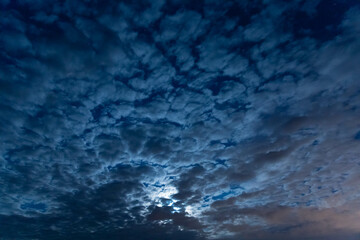 Moon in the night sky among the clouds