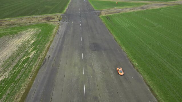 Coming down to Supercar Trackday on Runway Airport Sports Car Exotics driving Drone aerial above