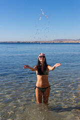 sexy woman in santa hat on sea beach