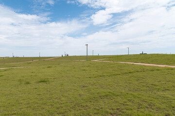View of the park on the green grass with the street lamps
