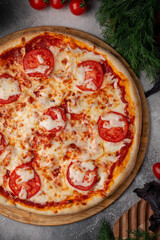 Tomato and cheese pizza with spiced tomatoes and cheese on a grey table