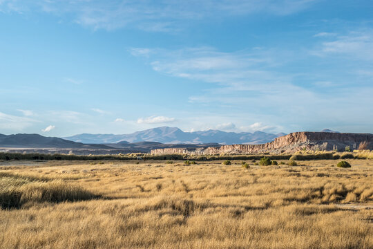 Valle con paredones naturales de rocas y monta&ntilde;as de fondo. 