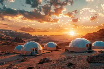 Türaufkleber Geodesic dome tents in a desert landscape at sunset with mountains in the background. © evgenia_lo
