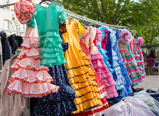 A rack of flamenco dresses hanging up - obrazy, fototapety, plakaty