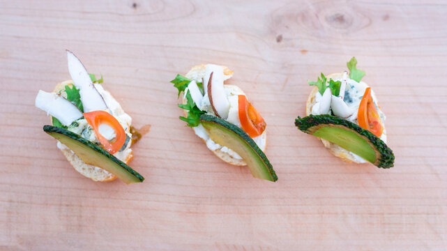 Finger food, bruschetti with salad, cheese , avocado and coconut.