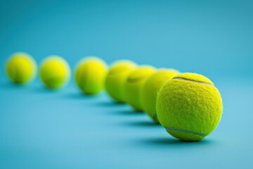 Row of Tennis Balls on Blue Surface with One in Front of Others