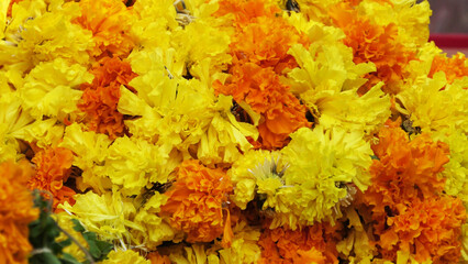 Red and yellow marigold flower garlands displayed in a flower shop