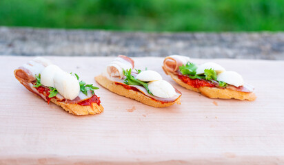 Finger food, bruschettas with salad, cheese , bacon , mozzarella.