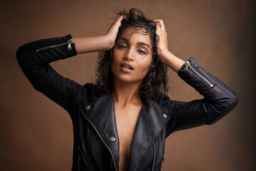 Woman, fashion and portrait in studio with leather jacket and beauty with makeup for bold, and...