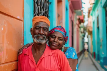 Foto auf Leinwand Smiling elderly couple embracing in a colorful alleyway in Havana, Cuba. travel tourism diversity multiethnic retirement lifestyle concept © evgenia_lo