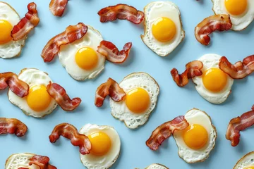  Breakfast composition with crispy bacon and fried eggs on a vibrant blue background in a flat lay style © SHOTPRIME STUDIO