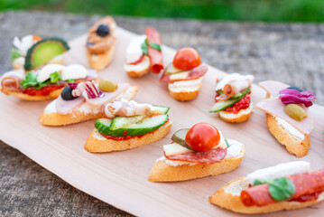 Finger food , various canapes with vegetables, ham, bacon , cheese and olives.