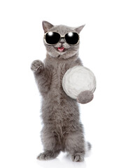 Happy cat wearing sunglasses holds big snowball. Isolated on white background