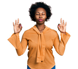 African american woman with afro hair wearing elegant shirt relax and smiling with eyes closed doing meditation gesture with fingers. yoga concept.