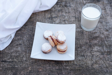 Freshly baked cookies on plate with glass of milk.