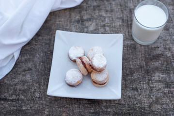 Freshly baked cookies on plate with glass of milk.