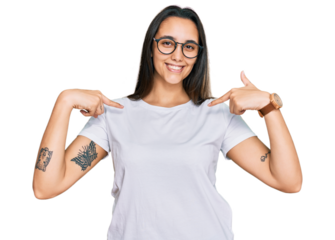 Young hispanic woman wearing casual white t shirt looking confident with smile on face, pointing oneself with fingers proud and happy.