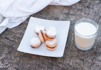 Freshly baked cookies on plate with glass of milk.