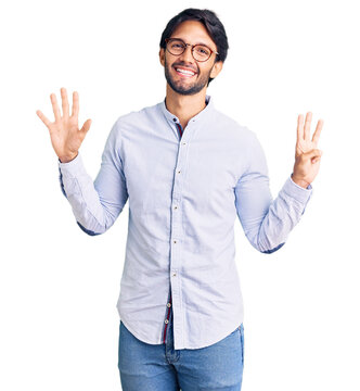Handsome hispanic man wearing business shirt and glasses showing and pointing up with fingers number eight while smiling confident and happy.