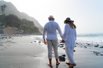 lifestyle with caucasian senior couple walking on beach, happy in love romantic and relax time,...