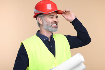 Architect in hard hat holding drafts on beige background