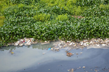 Water pollution in rivers with trash. Human impacts on the environment. Plastic and garbage from...