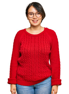 Young beautiful hispanic woman with short hair wearing casual sweater and glasses with a happy and cool smile on face. lucky person.