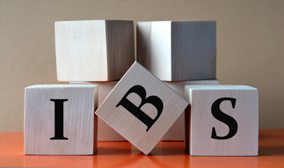 IBS - acronym on large wooden cubes on light brown background
