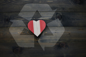 wooden heart with national flag of peru near reduce, reuse and recycle sing on the wooden...