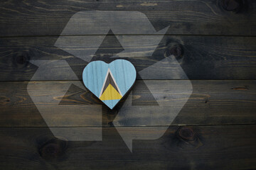 wooden heart with national flag of saint lucia near reduce, reuse and recycle sing on the wooden background.concept